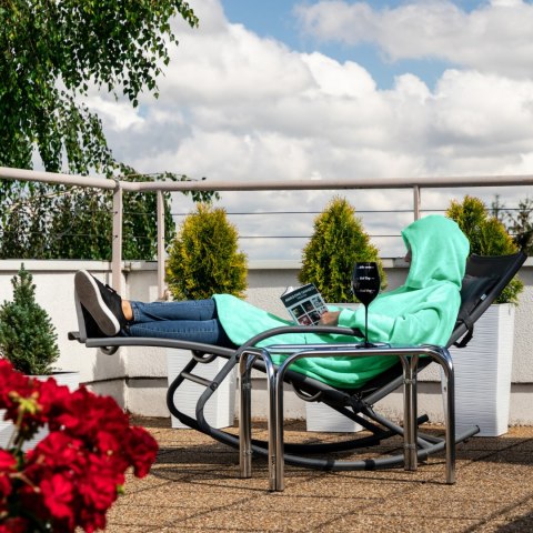 Osoba relaksująca się na leżaku w miętowej bluzie kocu z kapturem - ciepła bluza oversize idealna na taras, balkon