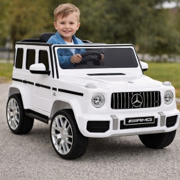 Biały samochód na akumulator Mercedes G63 AMG dla dzieci z chłopcem za kierownicą