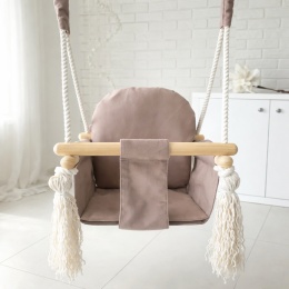 Beżowa drewniana huśtawka dla dziecka w stylu boho zawieszona w jasnym, minimalistycznym wnętrzu