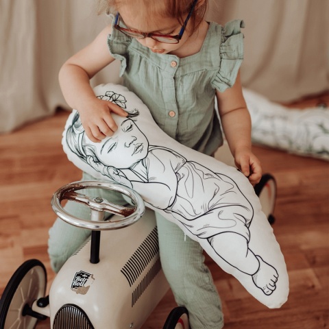 Dziecko trzymające poduszkę newborn z ilustracją niemowlęcia – poduszka dekoracyjna dla dzieci