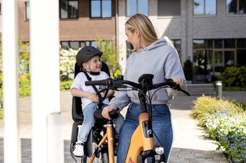 Dziecko w czarnym kasku Bobike podczas jazdy w foteliku rowerowym
