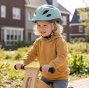 Dziecko w miętowym kasku BOBIKE podczas jazdy na rowerku biegowym