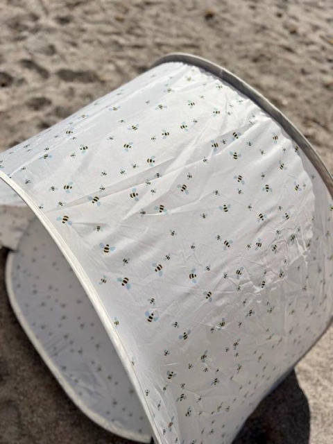 Detal namiotu plażowego dla dzieci Vanilla Copenhagen w pszczółki z ochroną UV50+ na plaży
