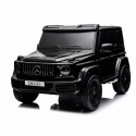 Czarny lakierowany Mercedes G63 4x4 XXL na akumulator dla dzieci ustawiony w ogrodzie podczas zabawy na świeżym powietrzu.