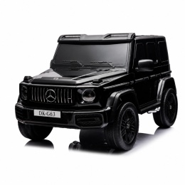 Czarny lakierowany Mercedes G63 4x4 XXL na akumulator dla dzieci ustawiony w ogrodzie podczas zabawy na świeżym powietrzu.