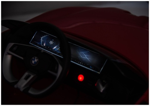 Kokpit z kierownicą i panelem sterowania w czerwonym BMW i4 na akumulator dla dzieci