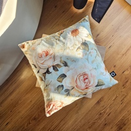 Poduszka dekoracyjna vintage w róże i margerytki FLORAL F47 na drewnianym stoliku w jasnym wnętrzu