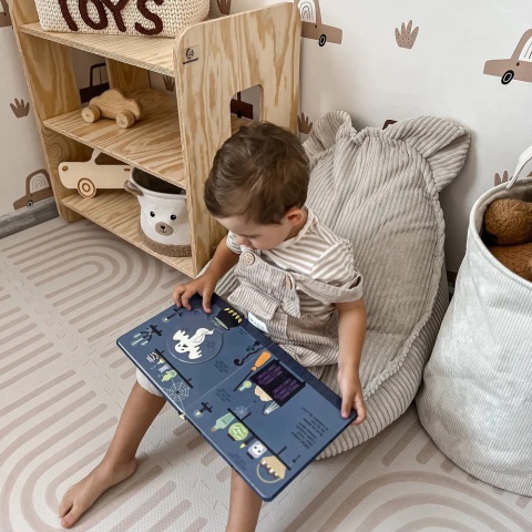 Dziecko czytające książkę na pufie Teddy Aesthetic ecru w pokoju dziecięcym