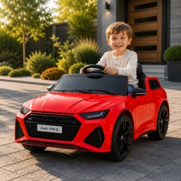 Czerwone Audi RS6 na akumulator dla dziecka podczas zabawy przed domem. Licencjonowany samochód elektryczny dla dzieci.