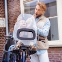 Dziecko w przednim foteliku rowerowym Bobike Mini z osłoną przeciwwiatrową i przeciwdeszczową