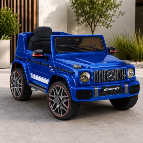 Mercedes AMG G63 niebieski na akumulator dla dzieci – licencjonowany samochód elektryczny w aranżacji ogrodowej.