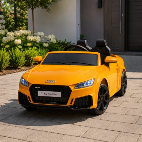 Żółte Audi TT RS na akumulator dla dzieci na tarasie przed domem – elektryczny samochód dziecięcy z pilotem i światłami LED