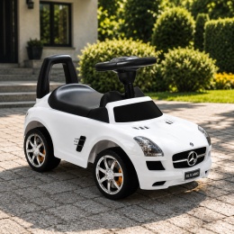 Biały jeździk Mercedes SLS AMG dla dzieci ustawiony na podjeździe przed domem