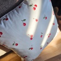 Poduszka dekoracyjna SUMMER SM68 w wiśnie na fotelu w naturalnym świetle