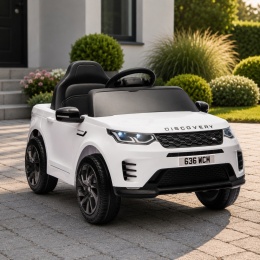 Biały Land Rover Discovery na akumulator dla dzieci zaparkowany przed domem w ogrodzie