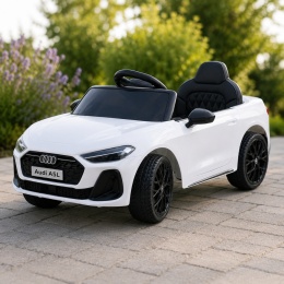 Białe Audi A5L na akumulator dla dziecka podczas jazdy na tarasie w ogrodzie