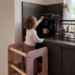 Dziecko korzystające z różowego kitchen helpera MeowBaby Montessori podczas pomocy w kuchni