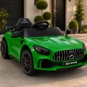 Zielony Mercedes GTR na akumulator dla dzieci przed nowoczesnym domem – samochód elektryczny z licencją Mercedes