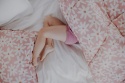 Różowa pościel bawełniana Blush Daisies w białe stokrotki z karmelowymi środkami, zbliżenie na wzór i materiał.