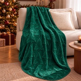 Zielony koc świąteczny NOELLE WINTER PINE z wypukłym wzorem choinek 3D, ułożony na beżowej sofie w eleganckim salonie