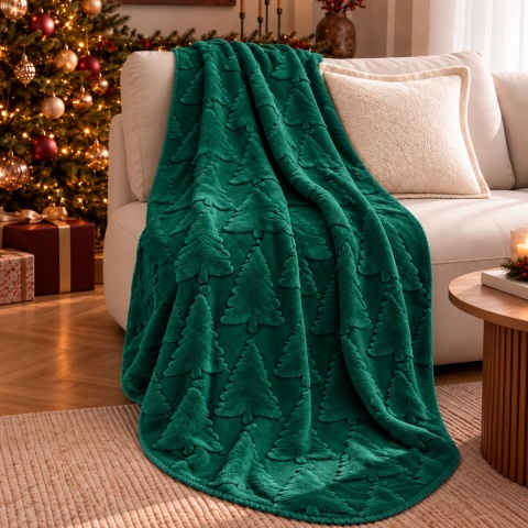 Zielony koc świąteczny NOELLE WINTER PINE z wypukłym wzorem choinek 3D, ułożony na beżowej sofie w eleganckim salonie