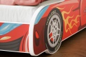 Detal czerwonego łóżka samochodowego Turbo 4x4 z grafiką sportowego koła, płomieniami i napisem Turbo Speed.