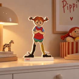 Lampka LED Pippi Pończoszanka o wysokości 35 cm z ciepłym białym podświetleniem, ustawiona na jasnej komodzie