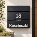 Czarna skrzynka na listy z numerem domu 18 i napisem Kościuszki, zamontowana na jasnej elewacji