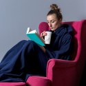 Kobieta w granatowej bluzie kocu z rękawami siedząca w fotelu i czytająca książkę - ciepła bluza oversize do domu